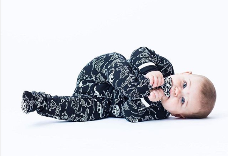 A baby wearing Peregrine Kidswear's dinosaur footed pajamas. Courtesy Peregrine Kidswear.